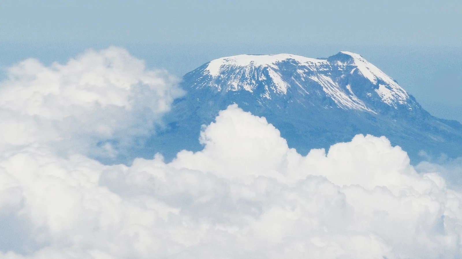 Aerial view of the Kilimanjaro summit breaking through the clouds